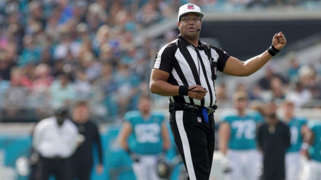 NFL referee Ron Torbert in uniform on the football during a game