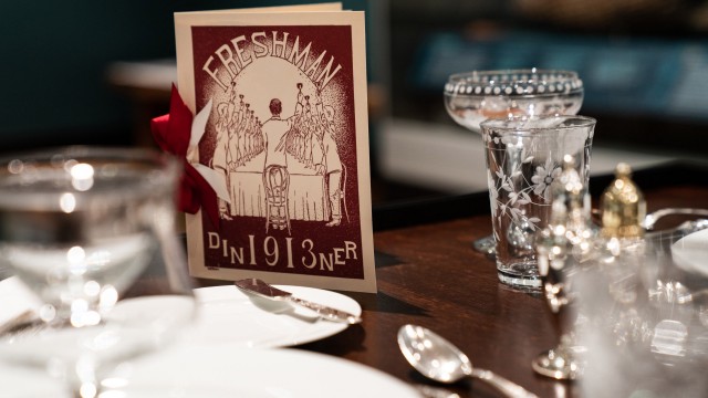 A table with a fancy menu and table settings.
