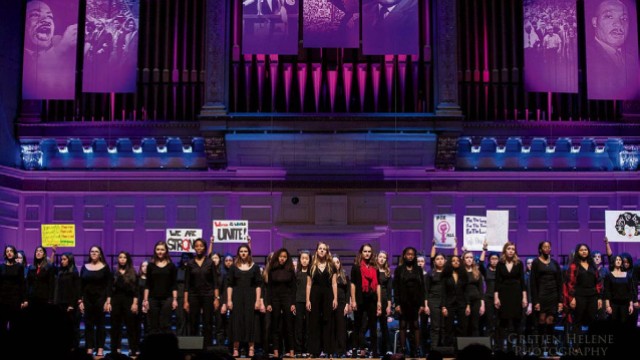 Children singers performing on stage with purple lighting 