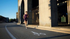 A man runs around the perimeter of Harvard Stadium