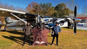 Alejandro Montagna standing in front of a small airplane wearing a wingsuit