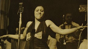 Blanche Calloway spreading her arms during a performance