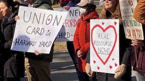 Organizers hold signs advocating for a union of non-tenure-track workers during a February rally in Harvard Yard