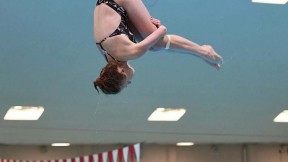 Georgina Milne flies through the air, flipping toward the water.