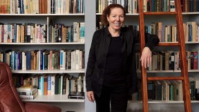 Wendy Lesser standing happily among her books 