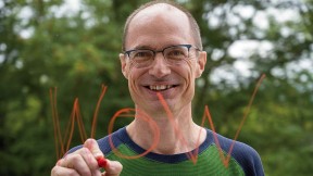 Mark Saltveit writes "Wow" on a piece of glass