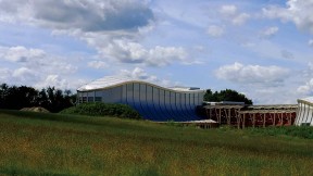 blue skies and green fields and music center building 