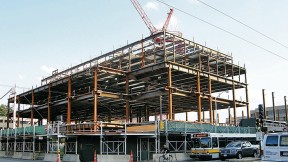 Structural steel is erected for the Law School’s Wasserstein Hall, Caspersen Student Center, and clinical-wing project on Massachusetts Avenue at Everett Street.