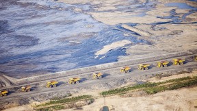 Huge dump trucks lined up in 2012 to transport tar sand from a surface mine, Fort McMurray, Alberta 