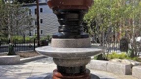 A silhouette can be seen in the negative space around the fountain at a Roxbury park.