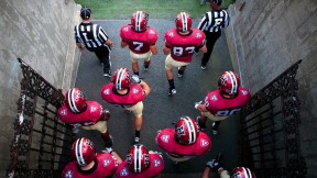 Photo of Harvard football players heading onto the field
