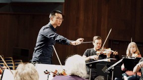 Sam Wu conducts an orchestra