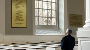In Memorial Church, General George W. Casey Jr. views the plaque commemorating the Harvard dead of the Vietnam War, among them his father, George W. Casey ’45.