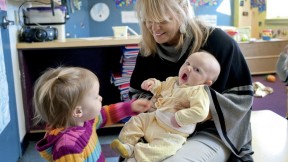 Mary Kinsella Scannell, vice president for early education and care, plays with baby Kinsey Ferraguto and toddler Margot Vorhees.