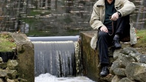 When not dealing with major global water issues, John Briscoe manages this small dam near his home. He holds the hook used to open the sluice gate.