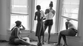 While being evicted from her Milwaukee apartment, Danielle Shaw (left) and relatives wait until the movers carrying down her refrigerator and stove are no longer blocking the stairwell. 