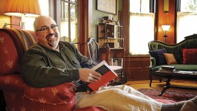 Poet and physician Rafael Campo relaxes at home with a book. 
