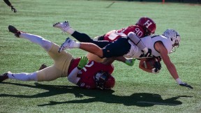  Harvard’s Truman Jones (90) and Khalil Dawsey corral Yale running back Joshua Pitsenberger. 