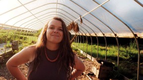 Reid Parsons stands in a greenhouse amid plants