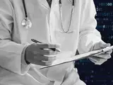 An image of a doctor writing set against a background of code, representing AI