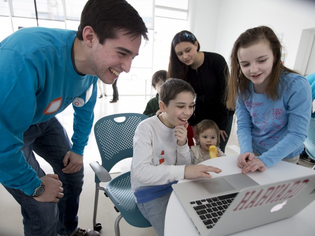 Photograph by Rose Lincoln/Harvard Public Affairs and Communications In the Ed Portal’s high-tech iStudio, Andreas Cruz ’17 teaches local students Jay Franks, age 11 (seated), and Cora Cloherty, age 10 (far right), how to use the Scratch programming language.