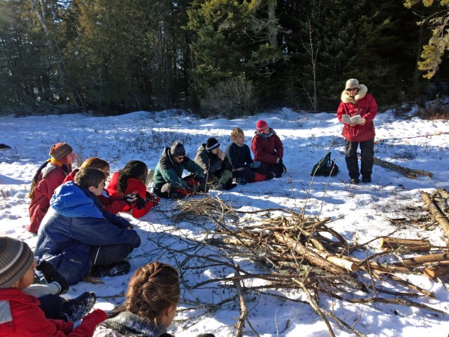 Photograph courtesy of Pforzheimer House During downtime, students listen to guide Polly Mahoney read about life in the wilderness.