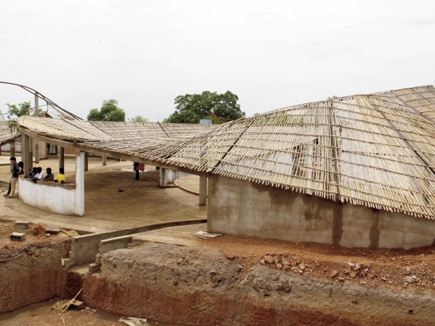 Photograph courtesy of Jordan MacTavish The undulating roof, constructed of local bamboo and thatch, is designed to catch rainwater for community use.