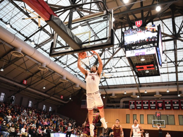 Chris Ledlum dunks the ball in the basket as opposing players trail behind him