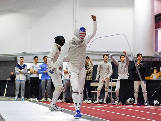 A fencer walks away from his opponent, holding up a fist