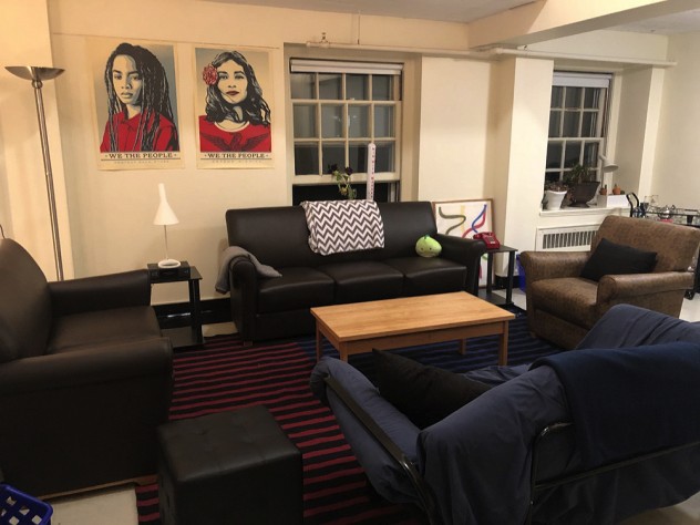 Photograph of the author's Harvard dorm room with chairs, sofa, posters