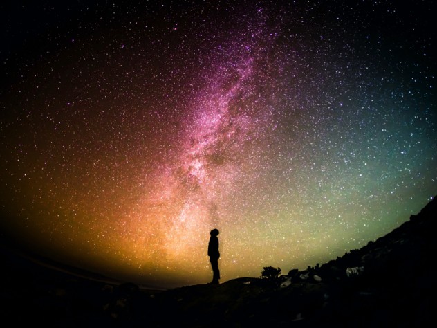 silhouette of person looking up from the ground at sky