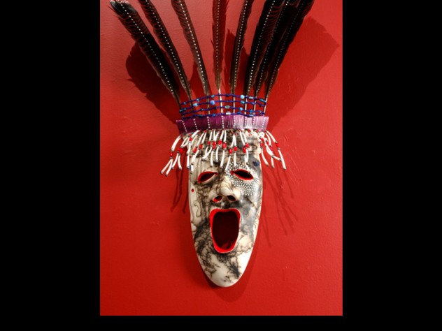 The <em>Arctic Dancer</em> mask demonstrates Charette's "horsehair firing" technique, which entails heating clay to 1,800 degrees Fahrenheit and dropping individual hairs onto it to produce a streaked effect. White "stars" around one eye represent a connection to the spirit world; below the other eye is a mole. Yup'ik lore holds that people with a mole near the eye are endowed with spiritual vision; Charette has a mole in the same spot, and uses the mark in his art as a signature.