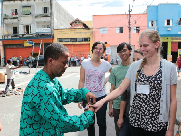 During a tour of a shantytown in the heart of São Paulo, a resident feigns a wedding proposal to HSPH’s Sarah MacDonald, as University of São Paulo's Ana Carolina Navarrete (left) and HSPH's Panji Hadisoemarto look on.