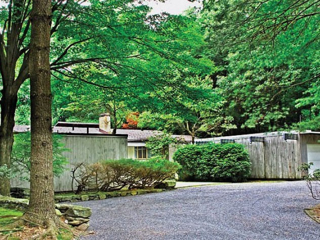 This low-lying, woods-bound home is located in the Peacock Farm enclave.