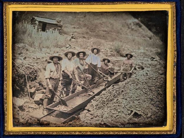 Gold miners working with a piece of gold-mining equipment called a long tom, circa 1850