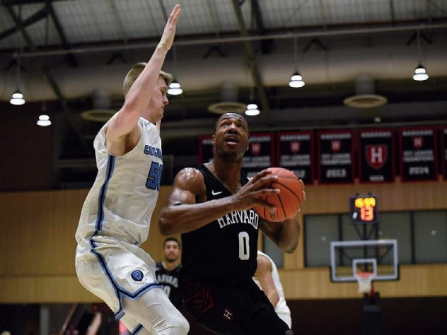 Chris Lewis, ball in hand, drives past opponent