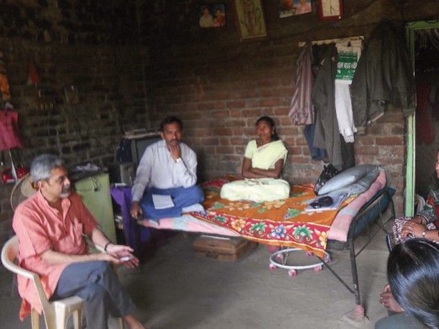 Photograph of Vikram Patel visiting with family members of a farmer in Maharashtra, India, who committed suicide
