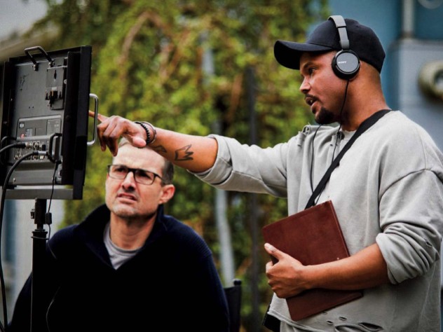 Screenwriter Julian Breece working with a colleague on set