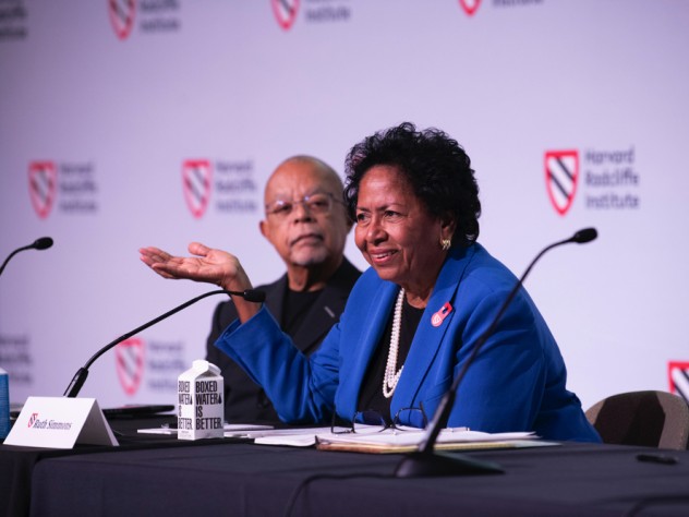 Ruth Simmons sits at a table on the stage with Henry Louis Gates, Jr. 