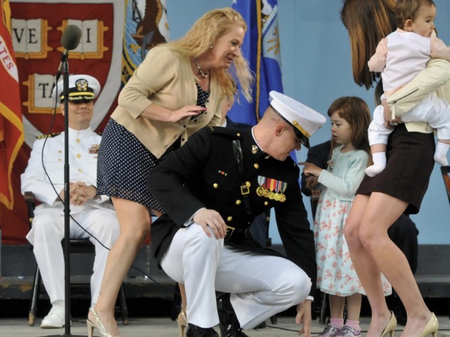 Photograph by Jim Harrison Second Lieutenant Taylor Evans ’14, already a veteran of five years in the Marine Corps, has his officer’s insignia pinned on by his family.
