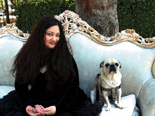 Author Gabrielle Zevin seated on a sofa in Los Angeles with her dog Nico