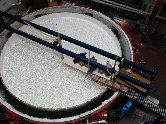 Photo by Ray Bertram, University of Arizona Mirror Lab technicians place each chunk of glass by hand atop the refractory blocks in the rotary kiln, preparing for final kiln assembly before firing.