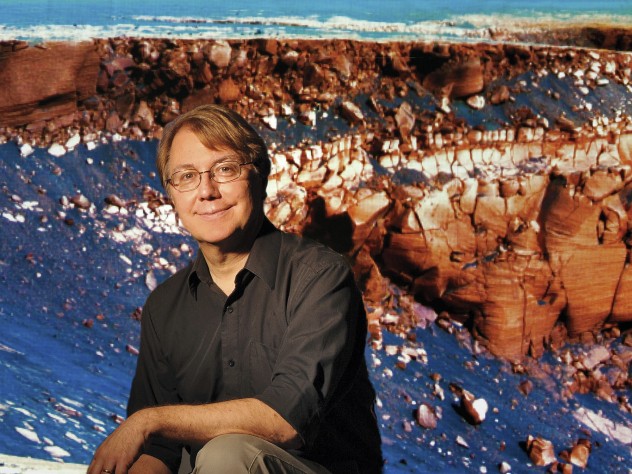 Photograph by Stu Rosner; background image NASA/JPL/Cornell Fisher professor of natural history Andrew Knoll, curator of the Harvard University Herbaria’s paleobotanical collections. Behind him is an outcropping of ancient sedimentary Martian rock, which he’s studied for NASA’s Mars Exploration Rover Mission.