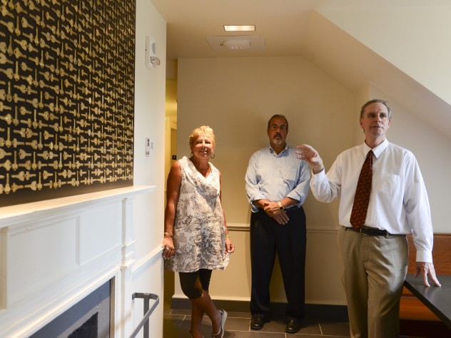 Architect Stephen Kieran (at right), Quincy co-master Deborah Gehrke, and Harvard's senior director of project management Steve Needham, point out that on upper floors, in a gesture to returning alumni, a graphic designer mounted old room keys (now replaced with electronic cards for access to entryways, floors, and rooms) in eight different patterns; they are hung over fireplaces. 