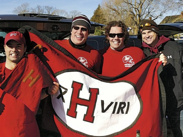 Photograph courtesy of Jared Lewis Members of the undefeated 2001 Crimson football team show flags at a 2011 tailgate in New Haven. Jared Lewis ’02, far left, holds the ancient Little Red Flag, which has been to many Harvard-Yale football games. He designed the new flag, and Kelly Goff made it. It is brandished, from left, by Justin Stark ’02, Jason Hove ’02, and Samuel Taylor ’02.