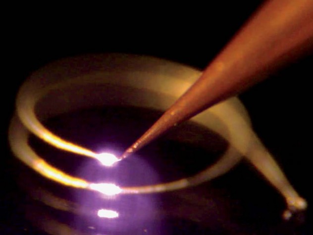 A 3-D printer “draws” a coiled antenna in the air. What allows the printer to work this way is a laser that hardens an “ink” of silver nanoparticles as they emerge from the nozzle.