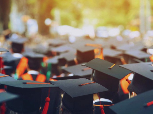 Photograph of students in caps and gowns graduating from college