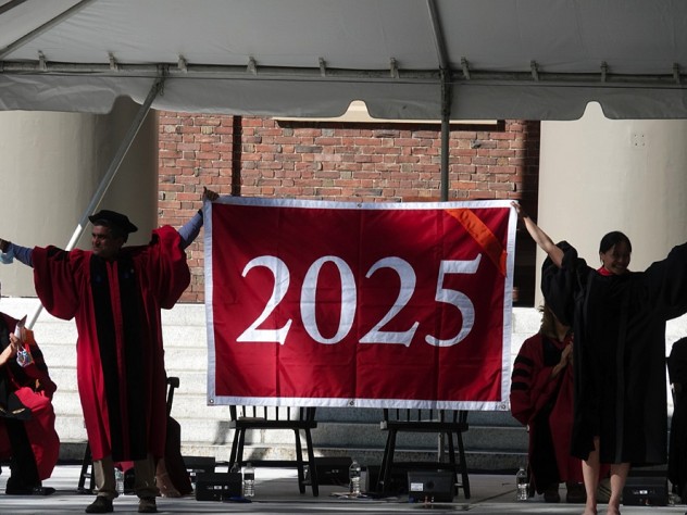 Danoff Dean of Harvard College Rakesh Khurana and Harvard Alumni Association president Vanessa Liu ’96, J.D ’03 unfurl the class of 2025 banner