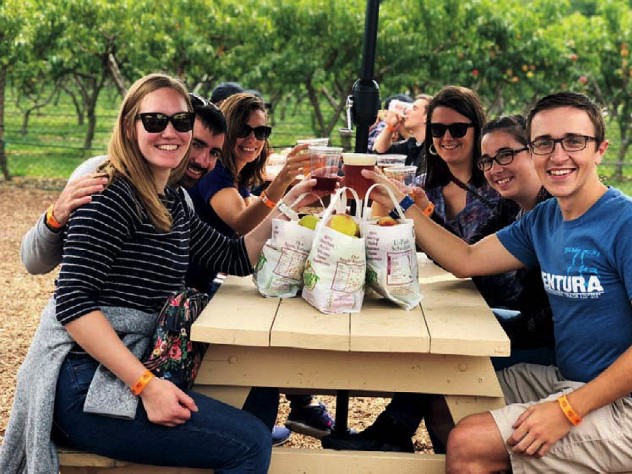 A group of people gather at one of Lookout's picnic tables after picking their own fruit