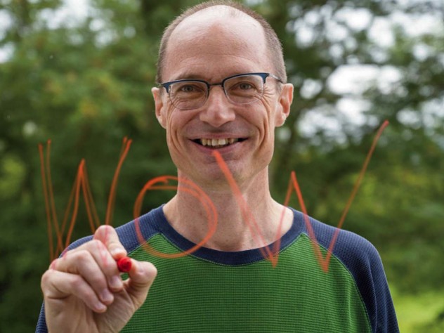 Mark Saltveit writes "Wow" on a piece of glass